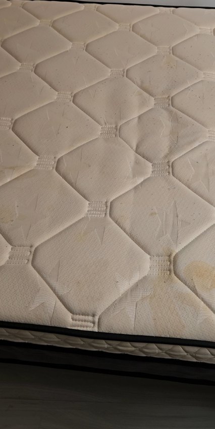 Colchão antes da higienização, com manchas amareladas